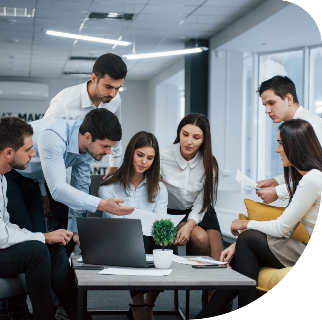 A group of people that examines a paper and looking slightly happy.